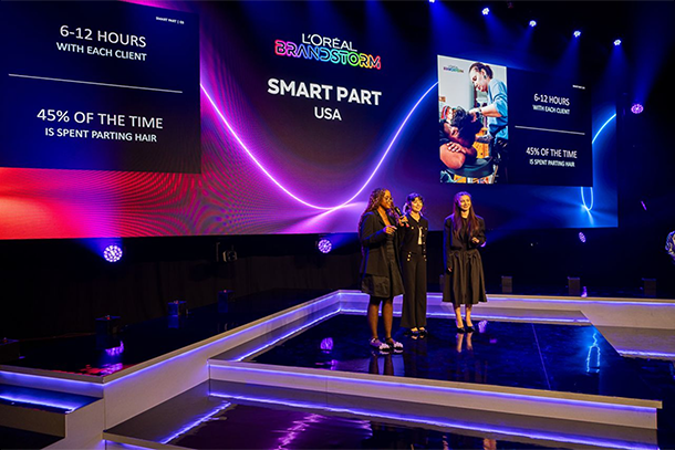 three students on stage at competition