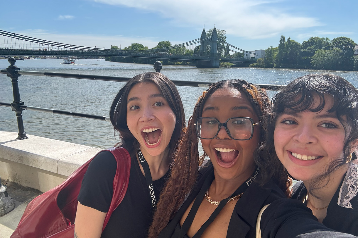 three students posing in front of london bridge