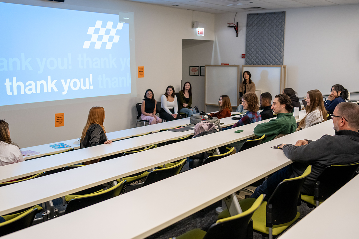 classroom with students and nascar representatives in seats with large screen saying  thank you